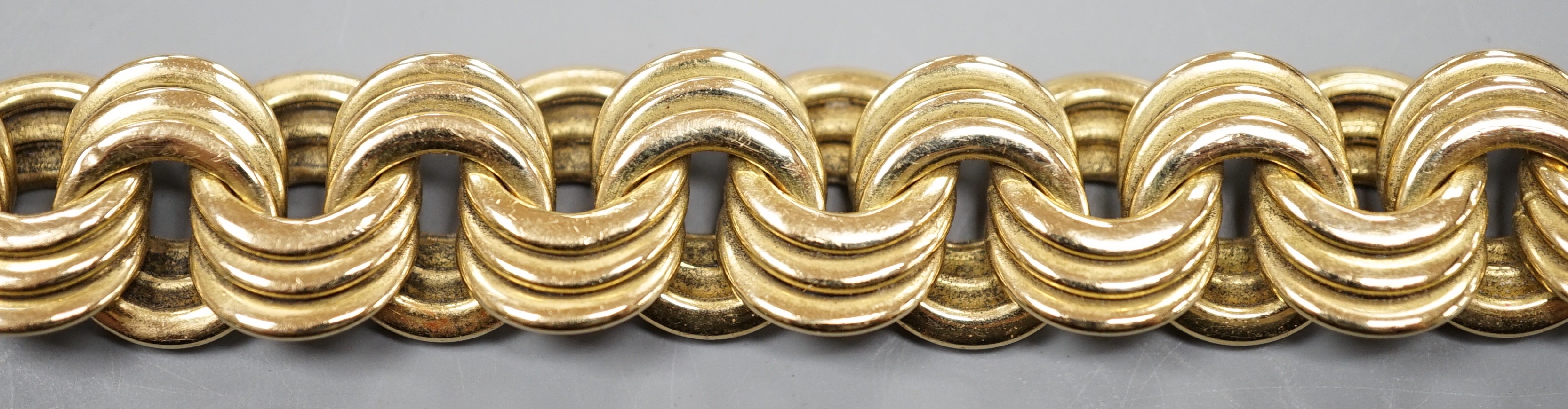 A yellow metal interwoven circular link bracelet, 21cm